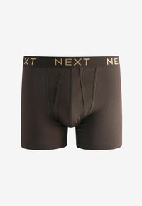 Boxer shorts en coton marron au design ajusté, avec une taille noire sur laquelle est imprimé "NEXT" en or. Deux coutures frontales pour un meilleur soutien.