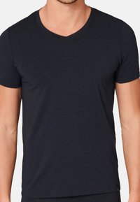 Kurzärmliges navy-blaues Baumwoll-T-Shirt mit V-Ausschnitt. Glatte Textur und taillierte Form mit einem kleinen Logo-Akzent am Saum.
