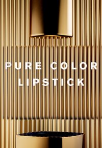 Tubo de lápiz labial dorado con un acabado brillante, que presenta una textura ribeteada vertical. Interior negro y texto en blanco llamativo que dice "LÁPIZ LABIAL COLOR PURO".