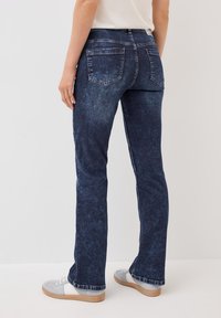 Donkerblauwe denim jeans met een aansluitend ontwerp, met twee achterzakken, subtiele whiskering en een licht vervaagde textuur.