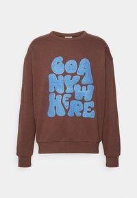 Felpa marrone con vestibilità comoda. Presenta un audace design testuale blu con la scritta "GO ANYWHERE". Tessuto morbido, polsini e orlo a coste.