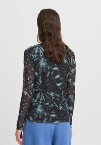 Langärmliges, schwarzes Batikshirt mit türkisfarbenen Mustern, aus transparentem Stoff gefertigt. Es hat einen runden Halsausschnitt und eng anliegende Ärmel.