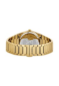 Reloj de metal dorado con un acabado liso, eslabones rectangulares y un fondo transparente que muestra una esfera de patrón. Cierre de hebilla ajustable.