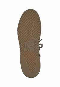 La semelle de la chaussure présente une surface en caoutchouc marron texturée avec un motif en chevrons et un logo "pg" en relief situé au centre.