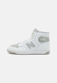 High-top sneaker in white and gray leather, featuring perforated toe, prominent "N" logo, padded collar, and textured rubber sole.