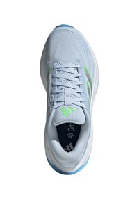 Zapato deportivo azul claro con parte superior de malla transpirable, acentos en verde y gris, cierre de cordones y suela acolchada.