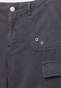 Pantaloni cargo grigio scuro realizzati in cotone con una texture liscia, dotati di una tasca frontale, bottone in metallo e due occhielli in metallo come dettagli.