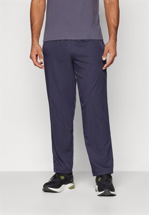Navy Sportpants aus leichtem Material mit geradem Schnitt und elastischem Bund. Kombiniert mit schwarzen Turnschuhen für einen Kontrast.