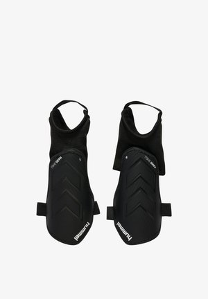 Paar schwarze linke und rechte Schienbeinschützer mit Knöchelärmeln und Riemenverschlüssen, beschriftet mit "Hummel" und "Hard Shell".