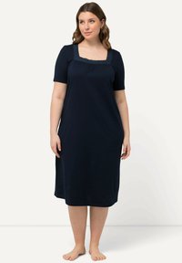 Námořnická noční košile vyrobená z jemného materiálu, s čtvercovým výstřihem lemovaným krajkou a krátkými rukávy, sahající do délky do poloviny lýtek.