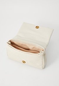 Bolso rectangular color crema con cierres de presión dorados, abierto para revelar un interior de tela beige con múltiples compartimentos.
