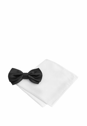 Black satin bow tie positioned on a white textured pocket square, showcasing sharp folds and clean edges.