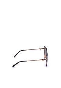 Vue latérale de lunettes de soleil avec des branches métalliques fines dorées et des embouts noirs sur fond blanc.