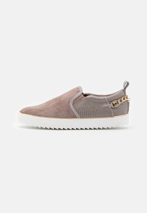 Slip-on sneaker with taupe suede front, textured grey back, white ridged sole, and gold chain detail near heel.