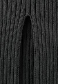 Tela de punto de canalé negra con un detalle de abertura vertical, mostrando textura y patrón de puntada en una vista de cerca.