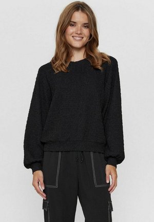Must mustriga sweatshirt pikka varrukaga ja ümmarguse kaelusega. Omab laia lõiget ja soonikkoes ääre. Koos mustade pükste ja taskutega.