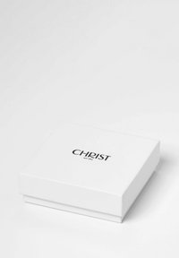 Weißer rechteckiger Kasten mit glatter Oberfläche. Schwarzer Text "CHRIST seit 1863" an der Oberseite. Minimalistisches Design, keine zusätzlichen Muster oder Akzente.