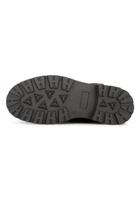 Suela de goma negra con un patrón de dibujo que presenta clavos y surcos triangulares para tracción. Construcción sólida, textura duradera.