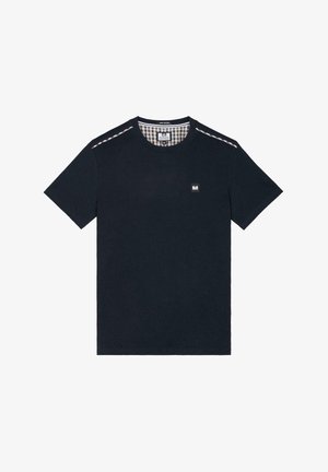 Tumši zila kokvilnas T-krekls ar apaļu kakla izgriezumu, īsām piedurknēm un rūtota raksta akcents uz pleca. Iespējams neliels zīmola logotips.