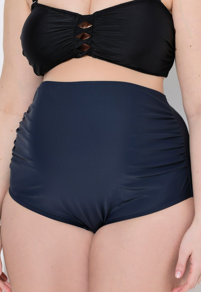 Tamarické plavkové spodky vysokého pasu v námořnické modré barvě se řasením po stranách, vyrobené z hladkého, elastického materiálu. Detaily přesného střihu a pokrytí jsou viditelné.