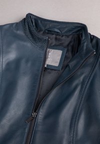 Navy leather jacket featuring a textured collar, zip closure, and smooth finish. Interior lined with a subtle pattern.