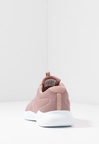 Růžová síťovaná atletická bota s texturovaným svrškem, kulatou špičkou, bílou podešví a poutkem na patě. Obsahuje decentní branding na straně.