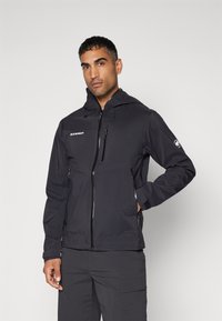 Schwarze Outdoor-Jacke mit Kapuze, ausgestattet mit einem Frontreißverschluss, zwei Seitentaschen und einem Logo auf der Brust und dem Ärmel. Glatte Textur.