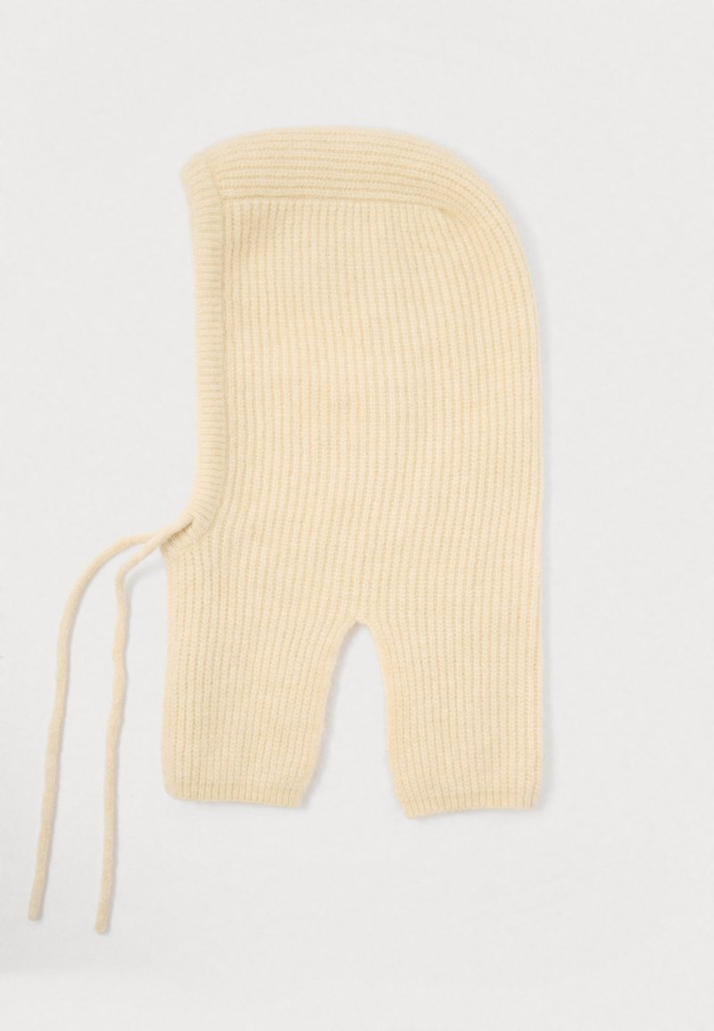 Balaclava in lana lavorata a maglia di un colore crema chiaro, caratterizzata da una texture a coste, una parte superiore arrotondata e un'apertura per il viso con lacci laterali per una vestibilità sicura.