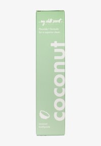 Grüne Verpackung für Kokosnuss-Zahnpasta. Enthält weißen Text und eine Illustration einer Kokosnuss. Glatte, matte Oberfläche.
