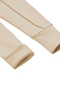 Lange mouwen beige kledingmanchetten met een gestructureerde gebreide afwerking. De stof is zacht, glad en lichtgewicht, met een eenvoudig, strak ontwerp.