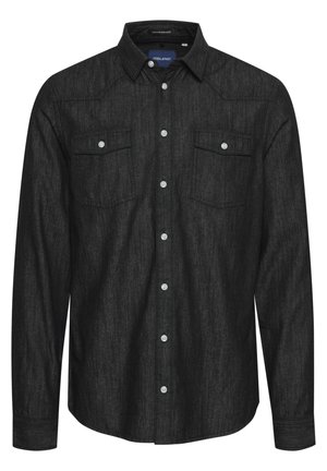 Chemise noire à boutons, réalisée en tissu texturé, avec des manches longues, deux poches poitrine avec rabats et des boutons blancs.