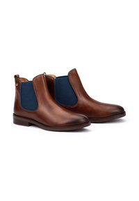 Pair of brown leather Chelsea boots with dark blue elastic side panels and low stacked heels on white background.