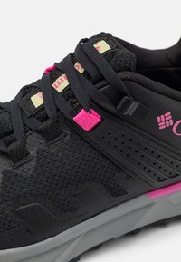 Czarny but sportowy z różowymi akcentami, teksturowana cholewka i wyściełany kołnierz. Posiada płaskie sznurowadła oraz trwałą gumową podeszwę z wzorami antypoślizgowymi.