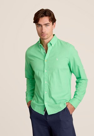 Groene, knoopsluiting overhemd gemaakt van lichtgewicht stof, met een puntige kraag en een klein logo op de borst. Draagt men met donkere broeken.