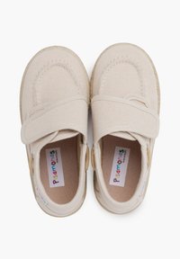 Scarpe in tela beige con design a punta arrotondata, cinturino regolabile, lati testurizzati e fodera interna morbida. Presentano etichettatura del marchio all'interno.