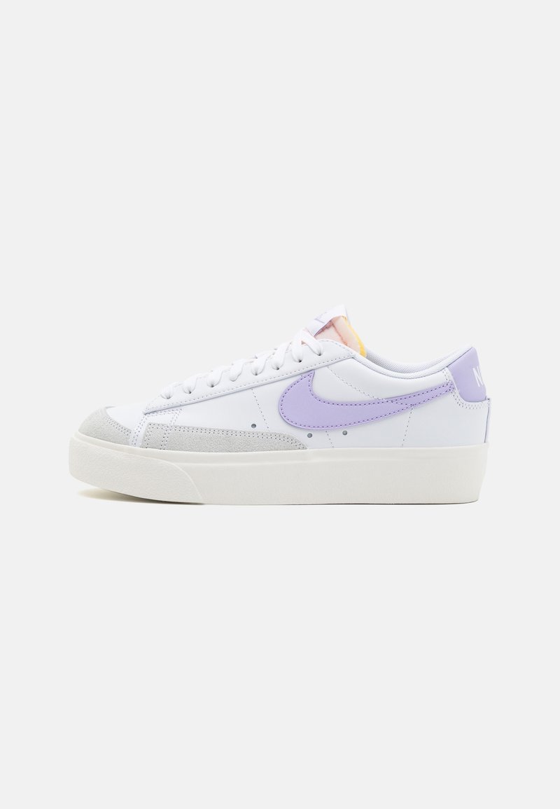 White sneaker with light purple accents, suede toe cap, and textured white sole. Features lace-up closure and branding on the heel.