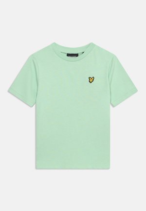 Vaaleanvihreä lyhythihainen T-paita pyöreällä kaula-aukkolla ja vasemmassa rinnassa pieni keltainen ja musta lintulogo.