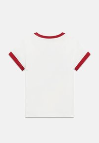 Weißes kurzärmeliges T-Shirt mit rotem, geripptem Kragen und Ärmelbündchen, von hinten auf hellem, einfarbigem Hintergrund gezeigt.