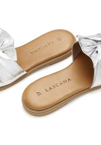 Silver metallic slide sandals with a bow detail, featuring a brown faux leather insole and a low, textured outsole. Size 37.