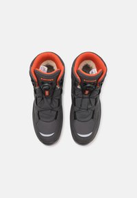 Scarpe da trekking nere con accenti arancioni, colletto imbottito, sistema di allacciatura BOA, tessuto testurizzato e dettagli riflettenti sulla punta.