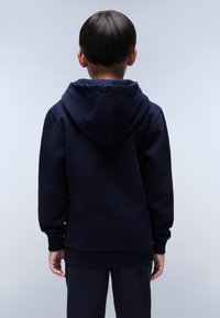 Navyblauwe hoodie van zachte stof, met een grote capuchon, ribgebreide manchetten en een ontspannen pasvorm. Zichtbare stiksels langs de naden.