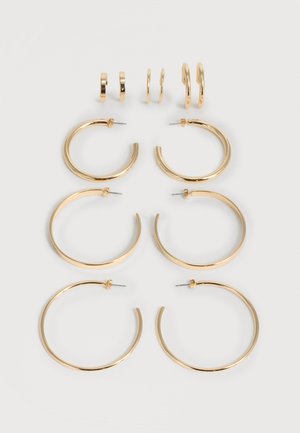 Έξι ζευγάρια χρυσά σκουλαρίκια κρίκοι σε αυξανόμενα μεγέθη, τοποθετημένα σε τρεις στήλες σε ανοιχτό φόντο.