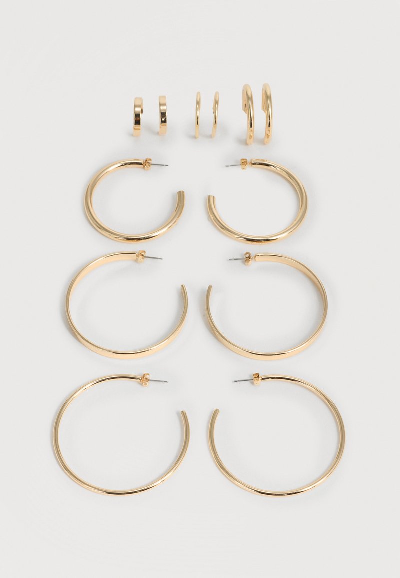 Έξι ζευγάρια χρυσά σκουλαρίκια κρίκοι σε αυξανόμενα μεγέθη, τοποθετημένα σε τρεις στήλες σε ανοιχτό φόντο.