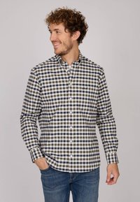 Chemise à carreaux en marine, blanc et gris clair. Design à boutons avec un col, des manches longues et un ourlet arrondi. Détail de logo subtil.