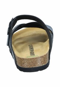 Black sandal featuring a cork footbed, adjustable strap with buckle, and textured sole. Notable for its ergonomic design and comfort.