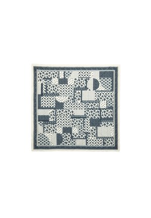 Bomuldsfrakke med et patchwork af marineblå mønstre på en cremefarvet baggrund, med forskellige former inklusive cirkler og blomstermotiver.