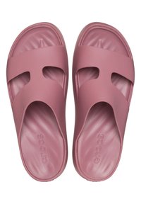 Růžové gumové skluzné sandály s dvěma výřezovými popruhy, hladkým povrchem a vytvarovanou stélkou pro pohodlí. Název modelu je vyražen na podrážce.