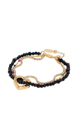 Brazalete dorado en forma de corazón con cuentas negras facetadas, pequeñas cuentas coloridas y una cadena ondulada de pedrería unida por un cierre y una cadena de extensión.