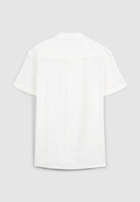 Camicia bianca a maniche corte realizzata in tessuto leggero. Presenta un colletto, una vestibilità morbida e un sottile motivo testurizzato sul retro.