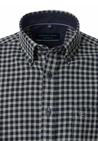 Niebieska i biała koszula w kratę z długim rękawem i kołnierzykiem na guziki. Posiada kieszeń na piersi i metkę z logo, wykonana z teksturowanej tkaniny.